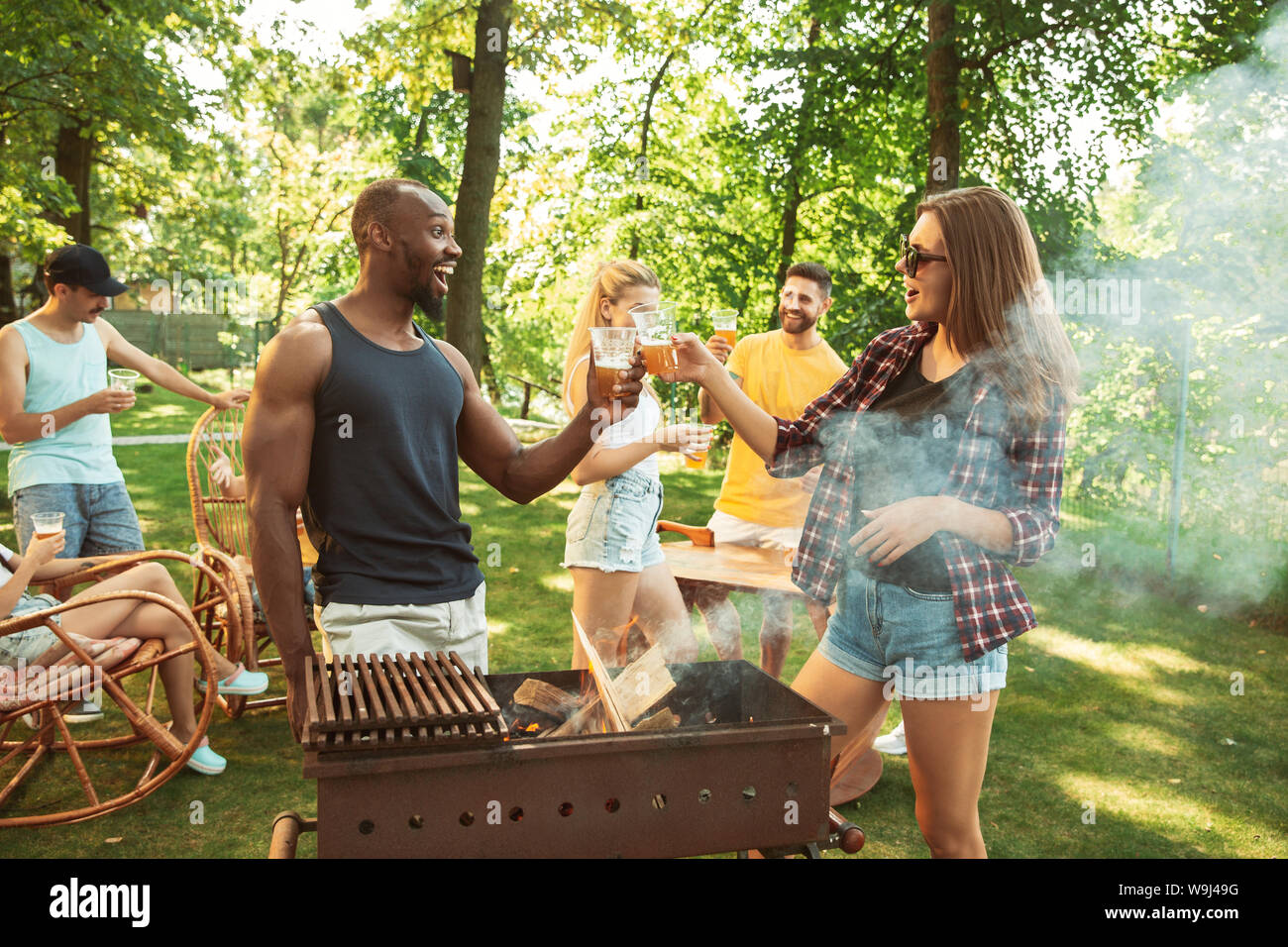 Group of happy friends having beer and barbecue party at sunny day ...