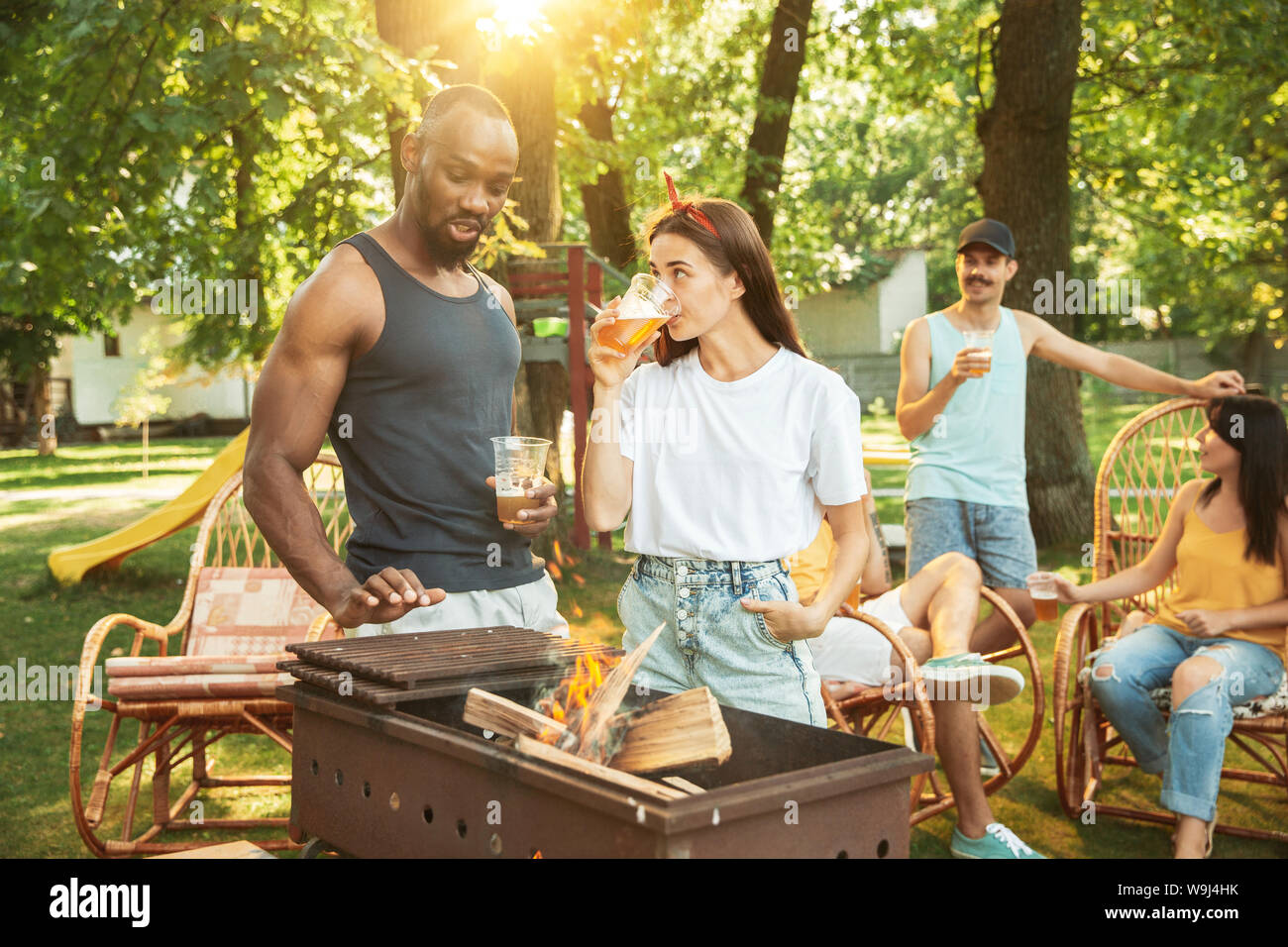 Group of happy friends having beer and barbecue party at sunny day ...