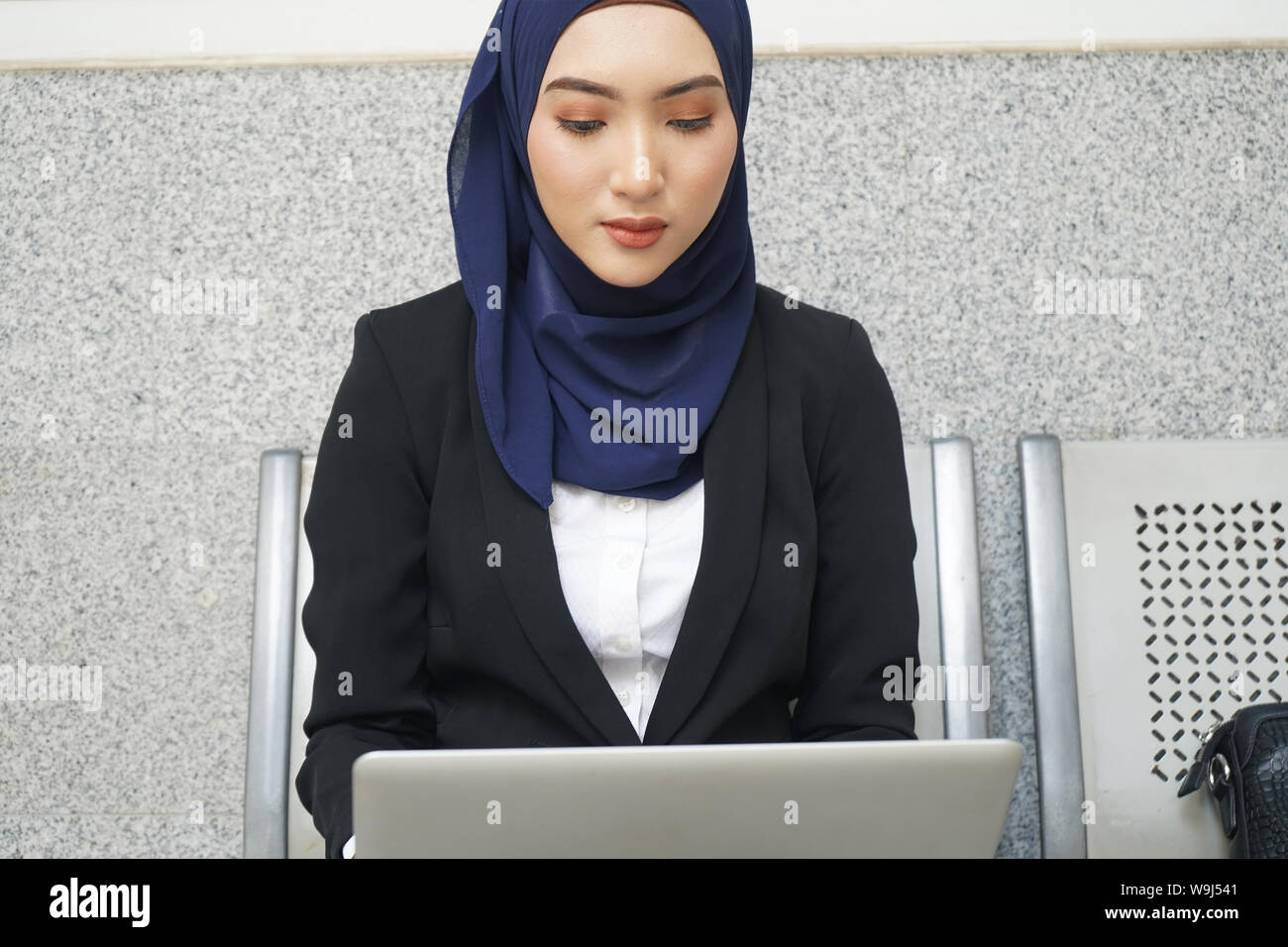 Muslim business woman working on a laptop on airport Stock Photo - Alamy