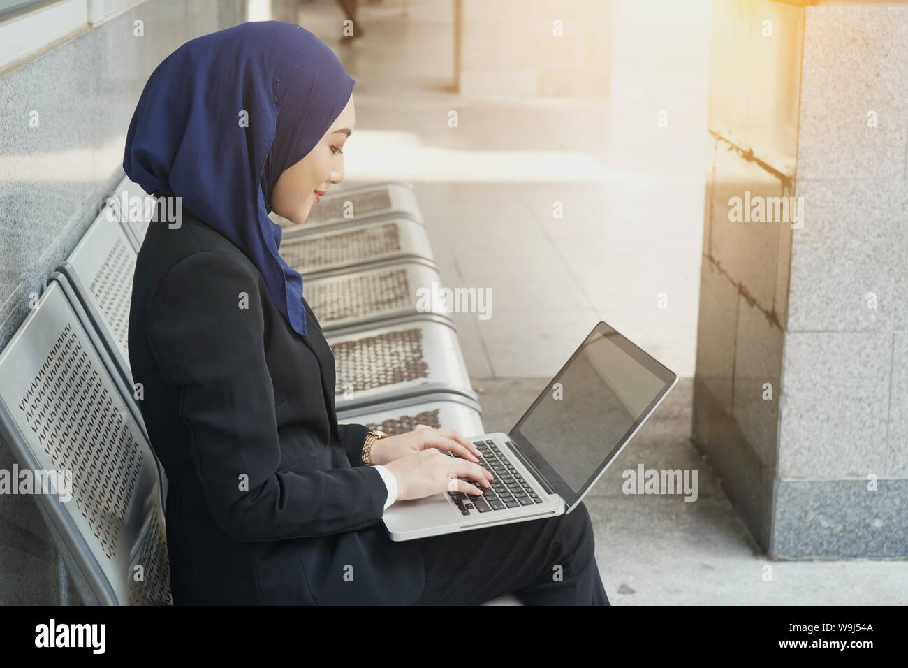 Muslim business woman working on a laptop on airport Stock Photo - Alamy