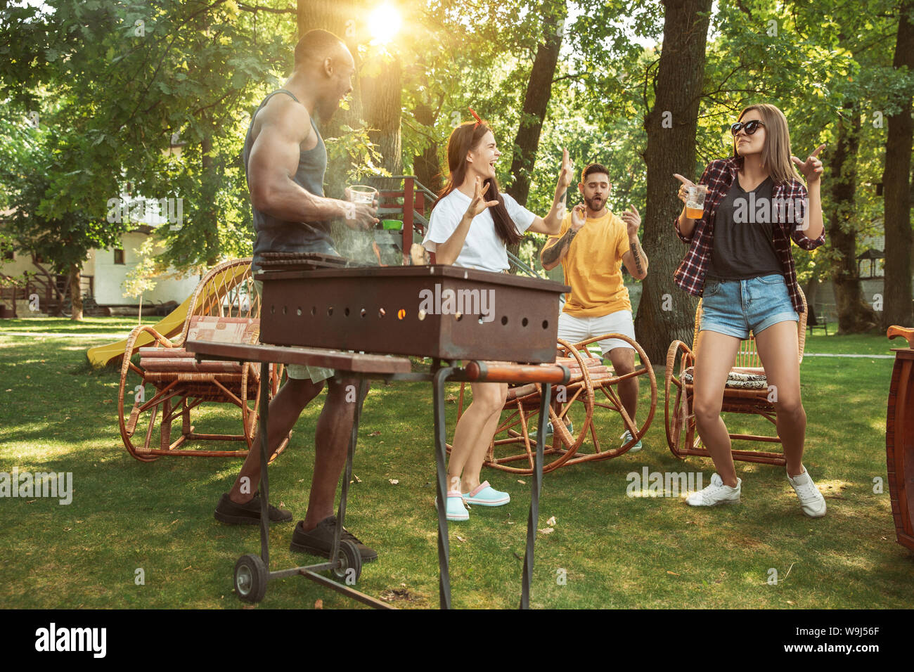 Group of happy friends having beer and barbecue party at sunny day ...