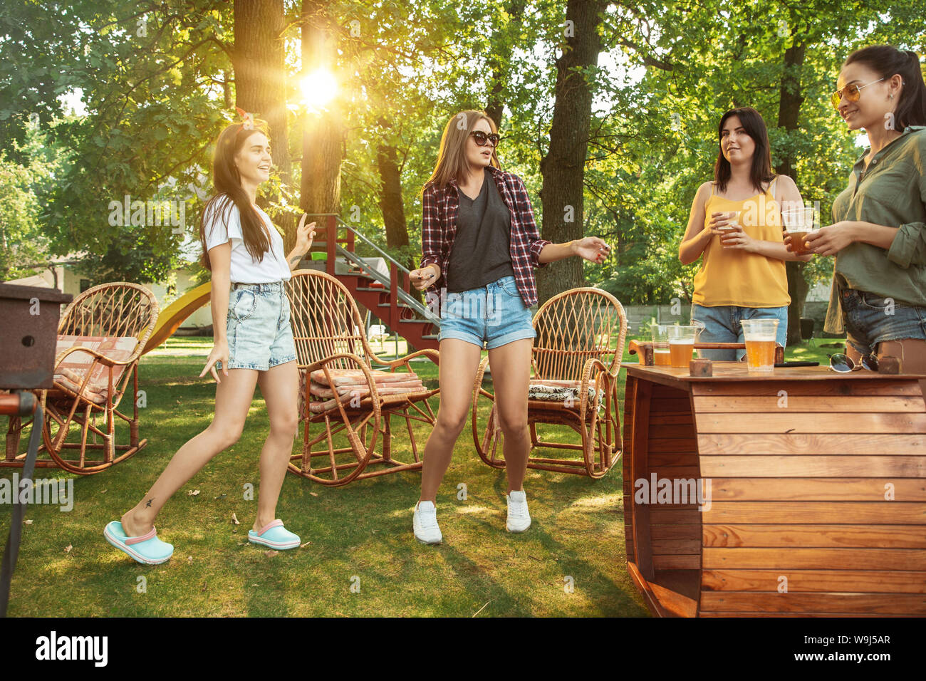 Group of happy friends having beer and barbecue party at sunny day ...