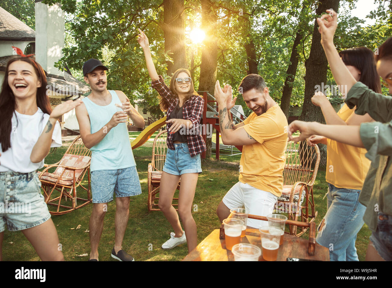Group of happy friends having beer and barbecue party at sunny day ...