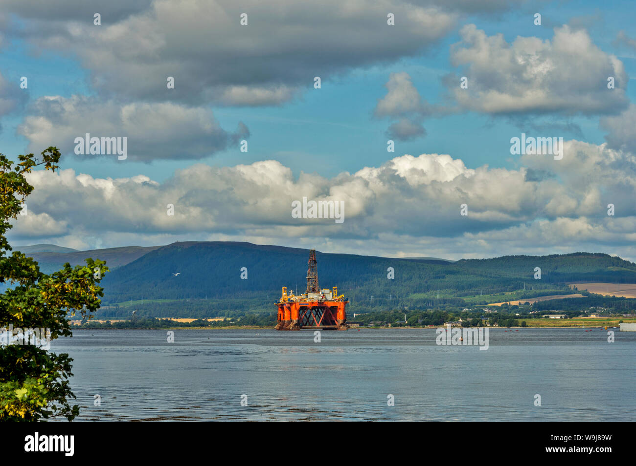 ORANGE OIL RIG PLATFORM UNDERGOING REPAIR OR DECOMMISSIONING CROMARTY FIRTH SCOTLAND IN SUMMER Stock Photo