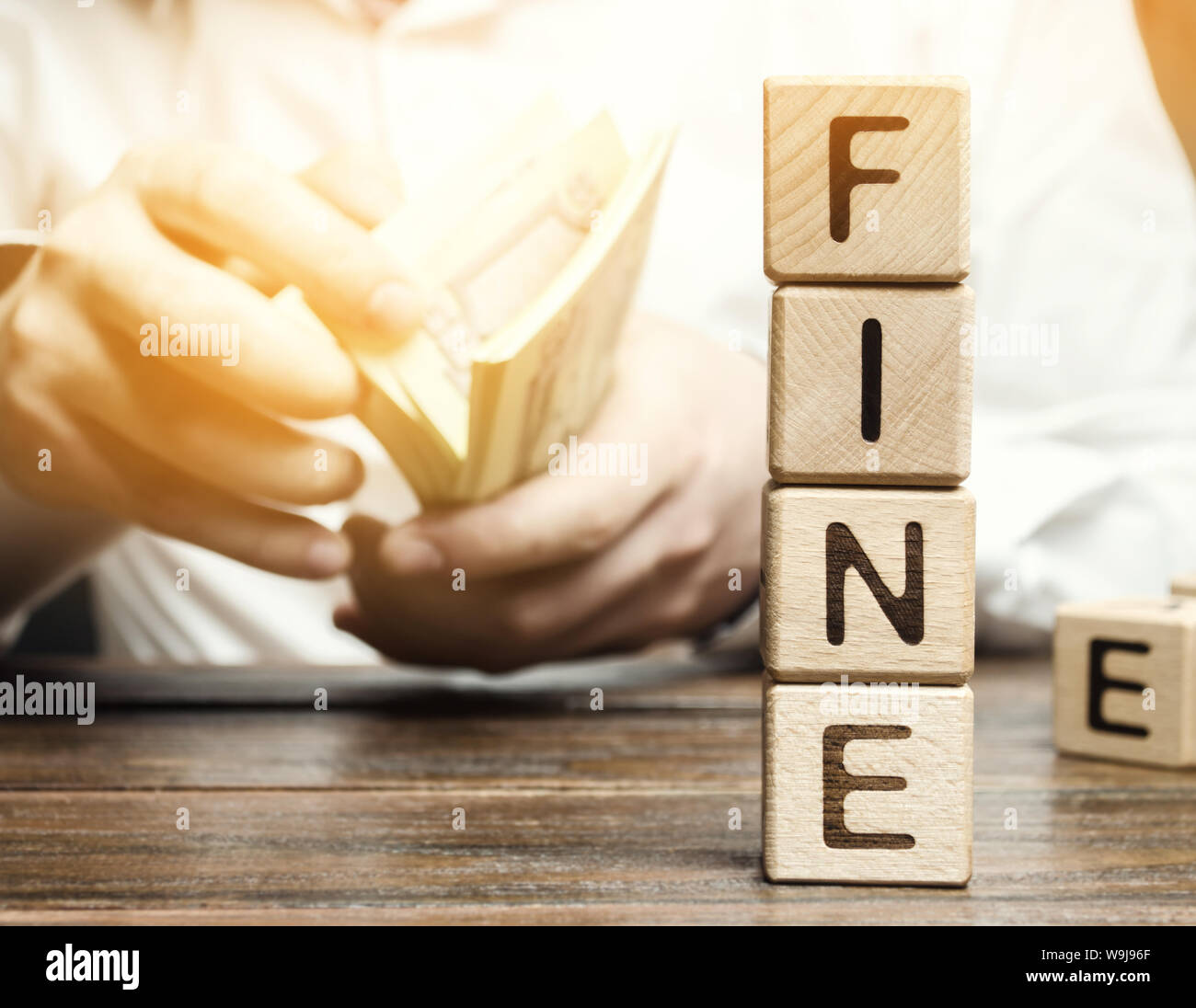 Wooden blocks with the word Fine and the man calculates the size of the ...