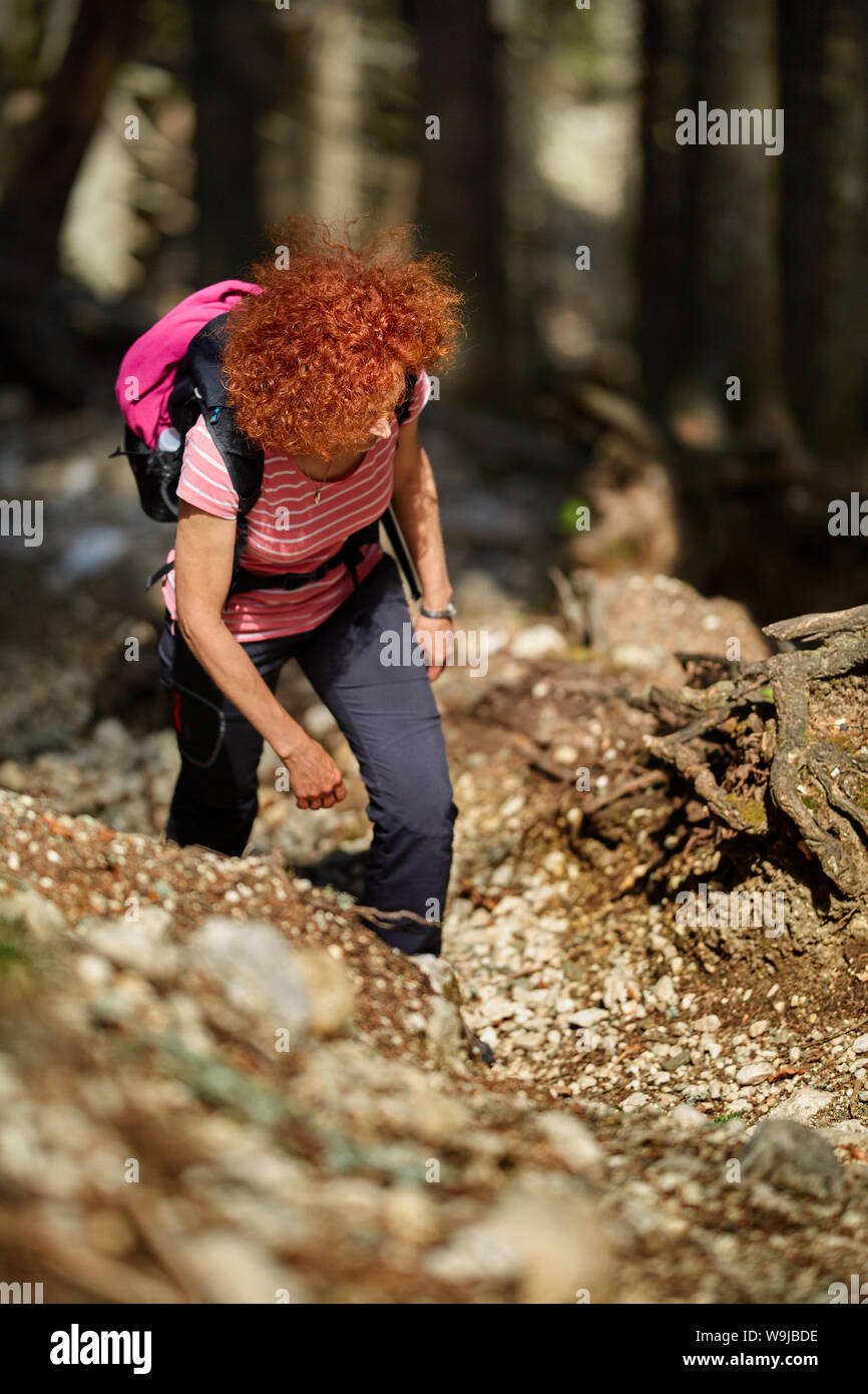 Curly redhead woman hiking on a trail in the mountains Stock Photo - Alamy