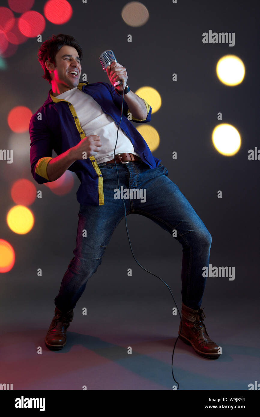 Man singing into microphone and dancing Stock Photo - Alamy
