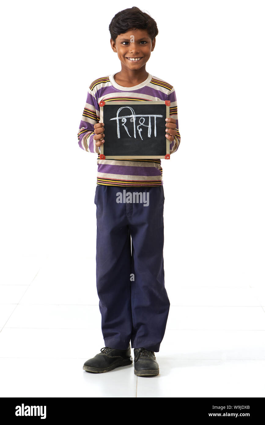 Boy holding a slate 'Shiksha' written on it Stock Photo