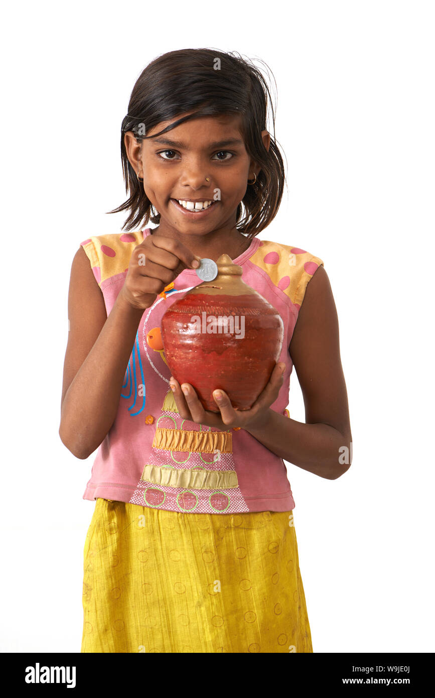 Girl inserting a coin into a piggy bank Stock Photo - Alamy