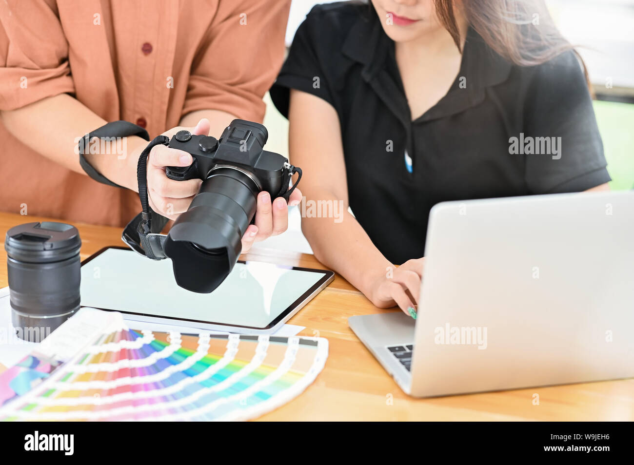 Cropped shot motivated meeting of photographer checking they camera in they modern workplace Stock Photo