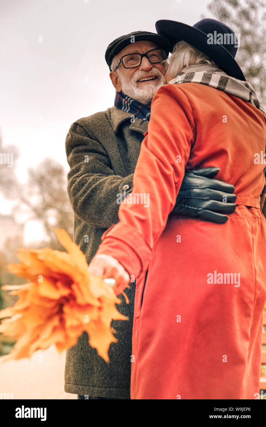 Low angle of a happy elderly couple hugging in park Stock Photo - Alamy
