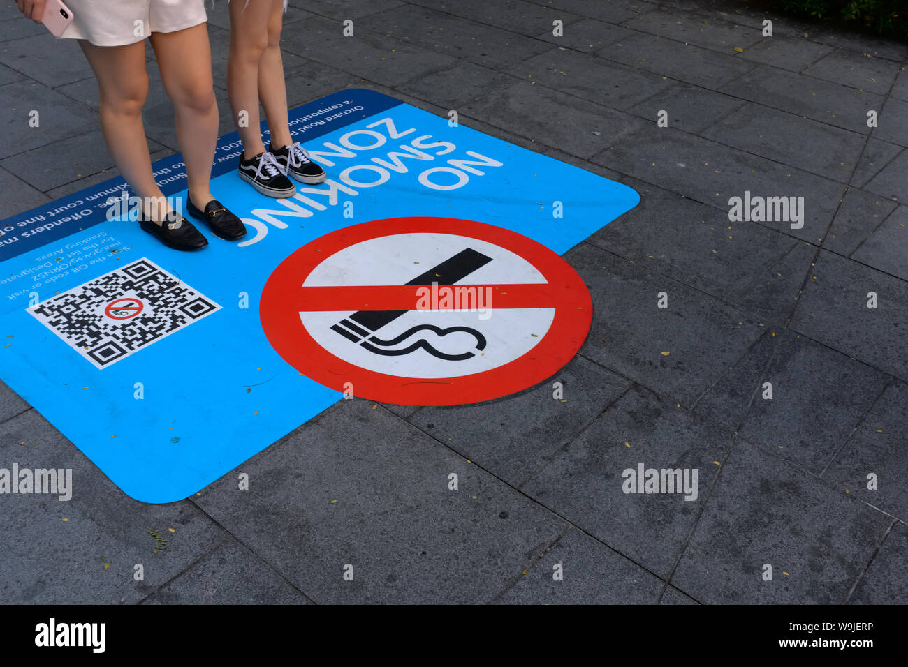 Luxury shopping precinct Orchard Road, Singapore, turned a non-smoking zone in 2019, and signs painted on the footpath warn trespassers of heavy fines Stock Photo