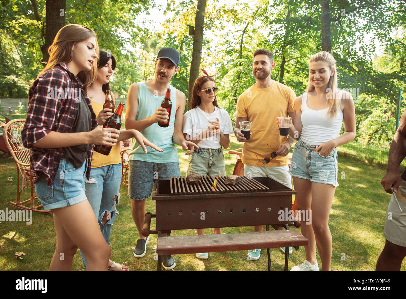 Group of happy friends having beer and barbecue party at sunny day ...