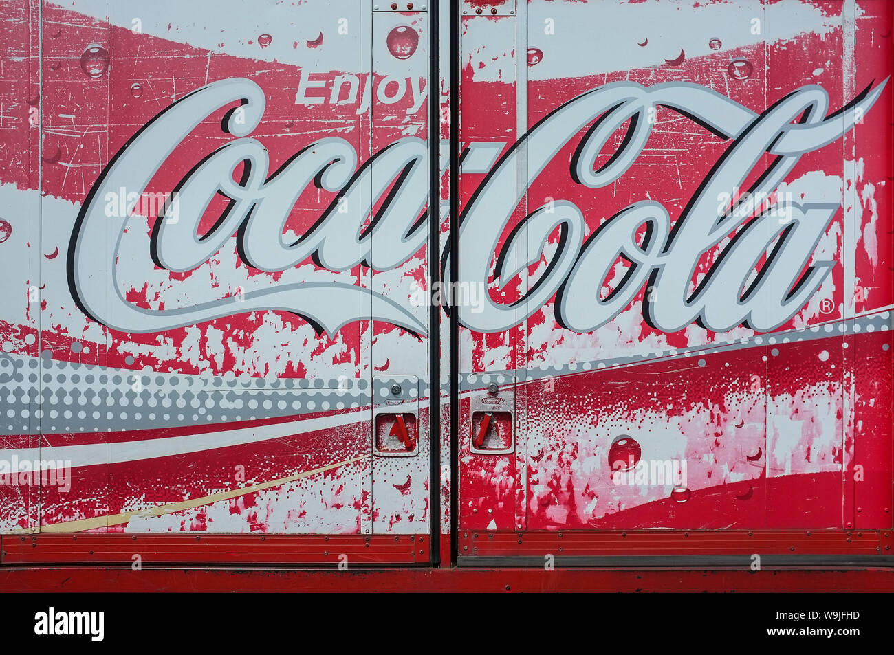 Sun damaged weathered coca cola logo on a delivery truck back doors. Stock Photo