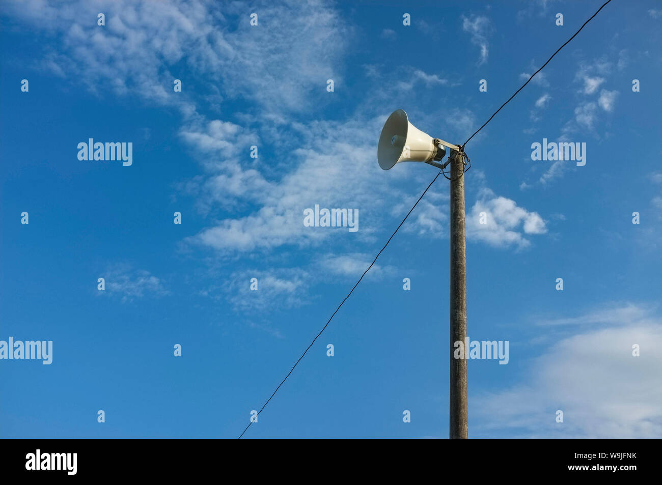 Loudspeaker atop a pole, against the sky. Stock Photo