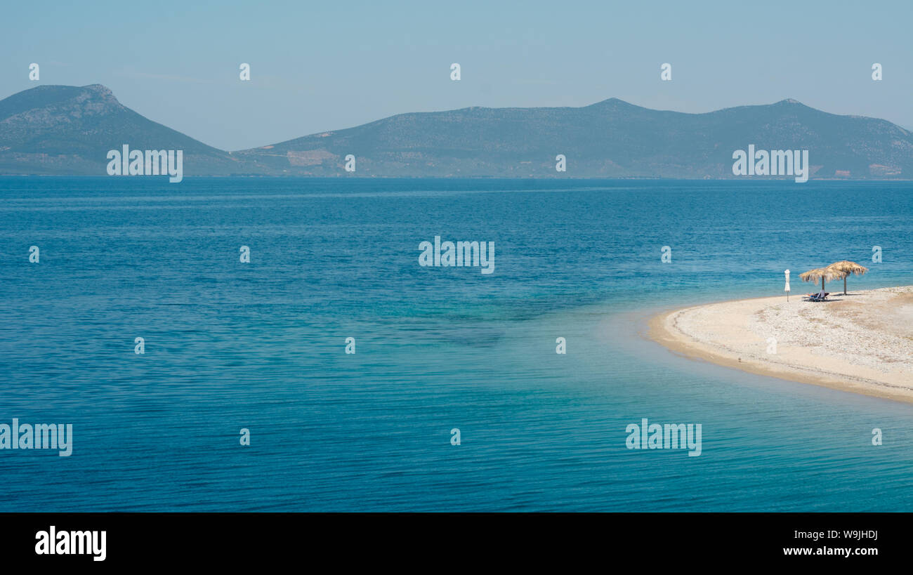 Empty beach on a Greek island with one sunshade Stock Photo
