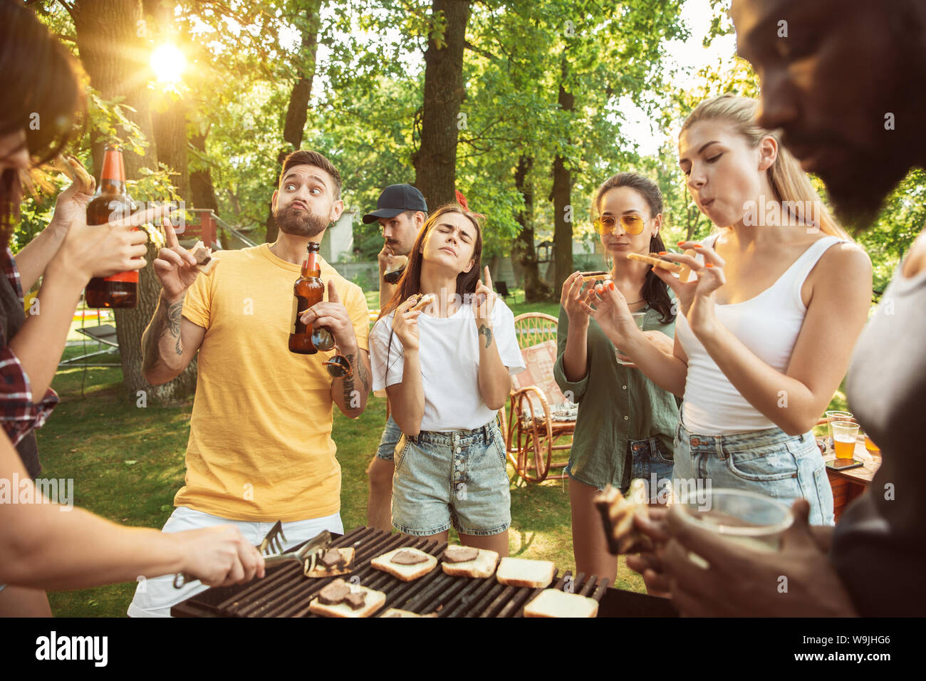 Group of happy friends having beer and barbecue party at sunny day ...