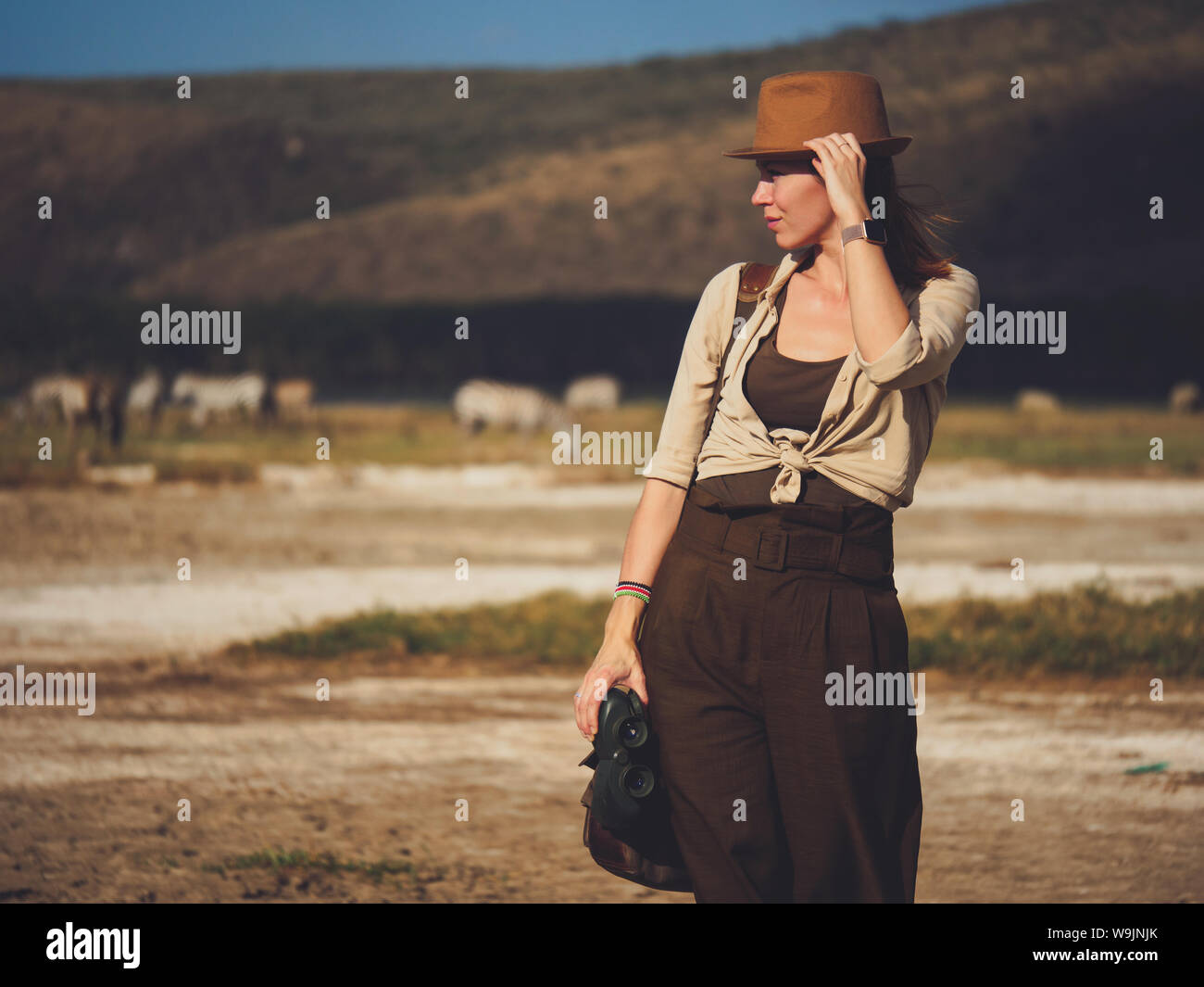 Beautiful woman with binoculars at savanna in Kenya Stock Photo Alamy