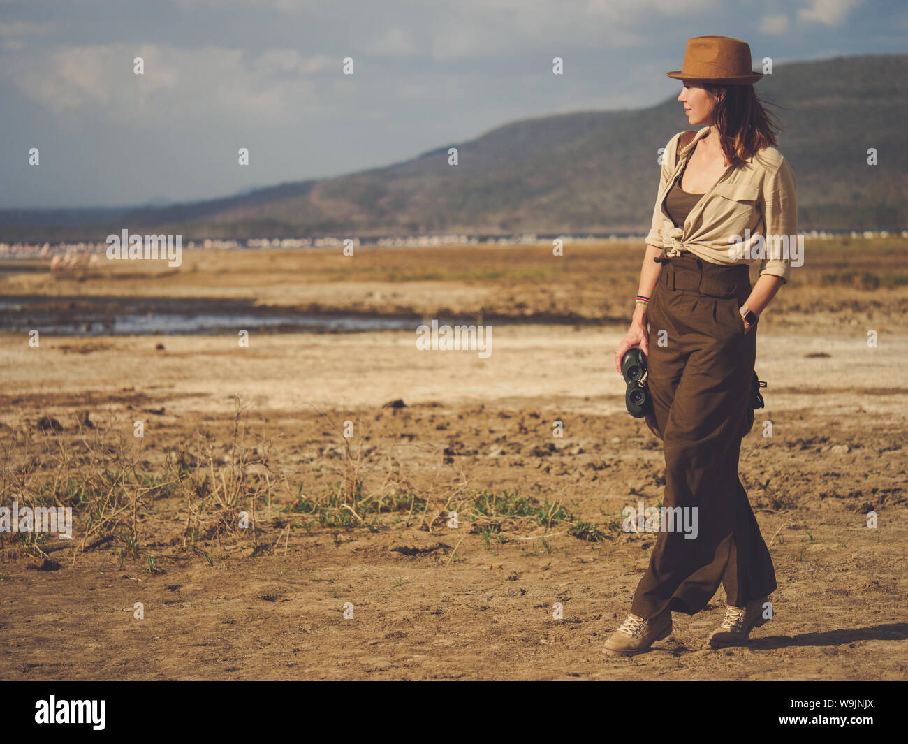 Beautiful woman with binoculars at savanna in Kenya Stock Photo Alamy