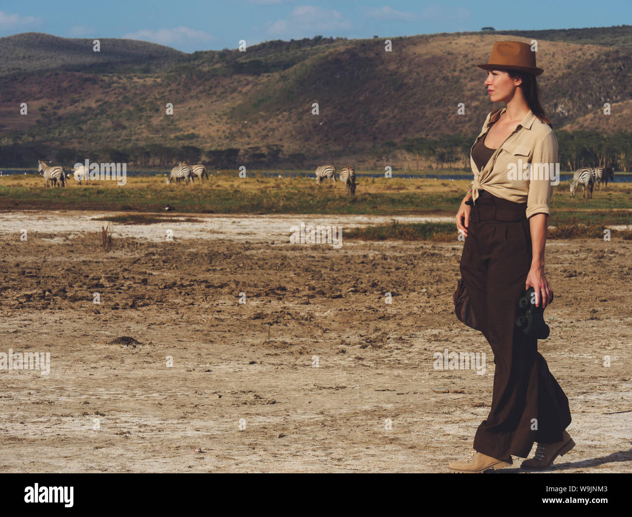Beautiful woman with binoculars at savanna in Kenya Stock Photo Alamy