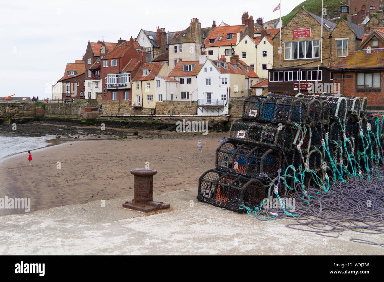 Quay beside RNLI Station in Whitby Harbour showing Lobster and Crab Creel with Old Town behind. Stock Photo
