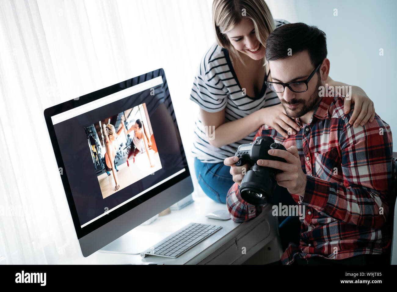 Young attractive designers working on project together Stock Photo