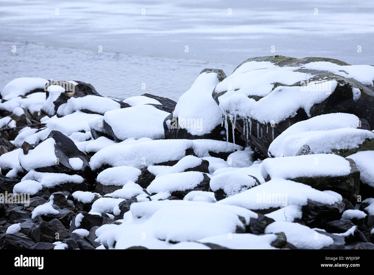 Rocks covered in snow at lake shore Stock Photo - Alamy