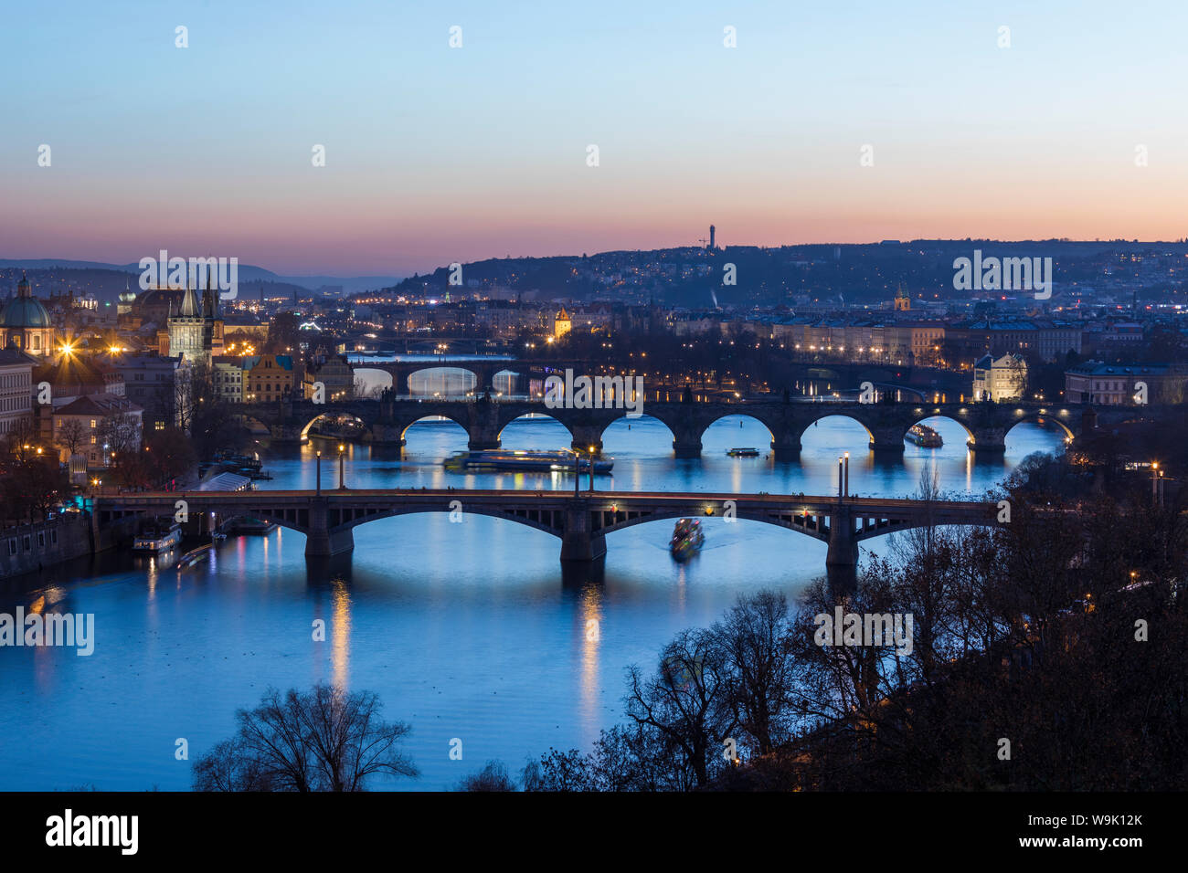 Dusk lights up the historical bridges and buildings reflected on Vltava River, Prague, Czech Republic, Europe Stock Photo