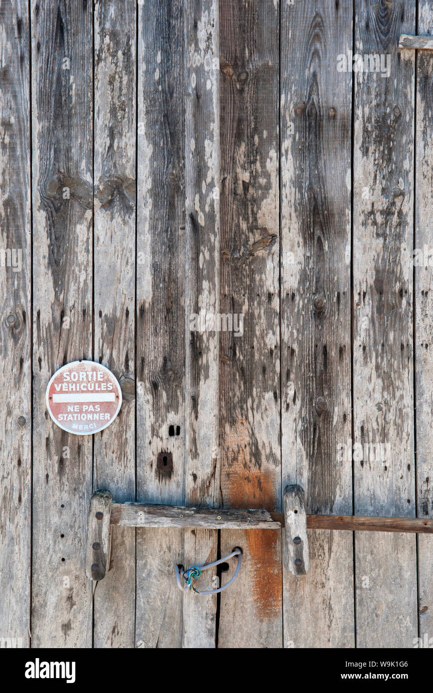 A No Parking Sign On An Old Weathered Wooden Door In The Dordogne