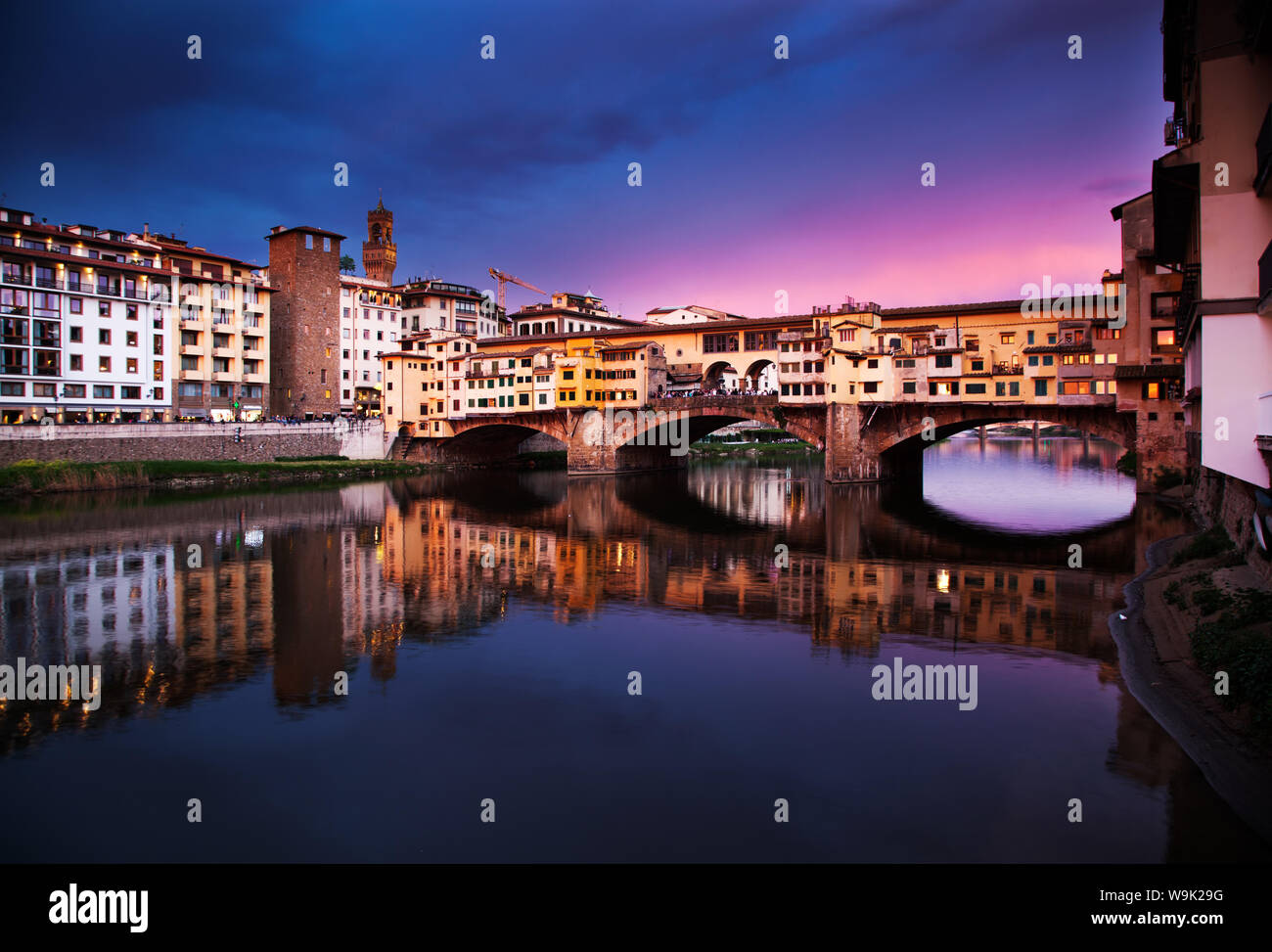 Ponte Vecchio at sunset reflecting in River Arno, Florence, UNESCO ...
