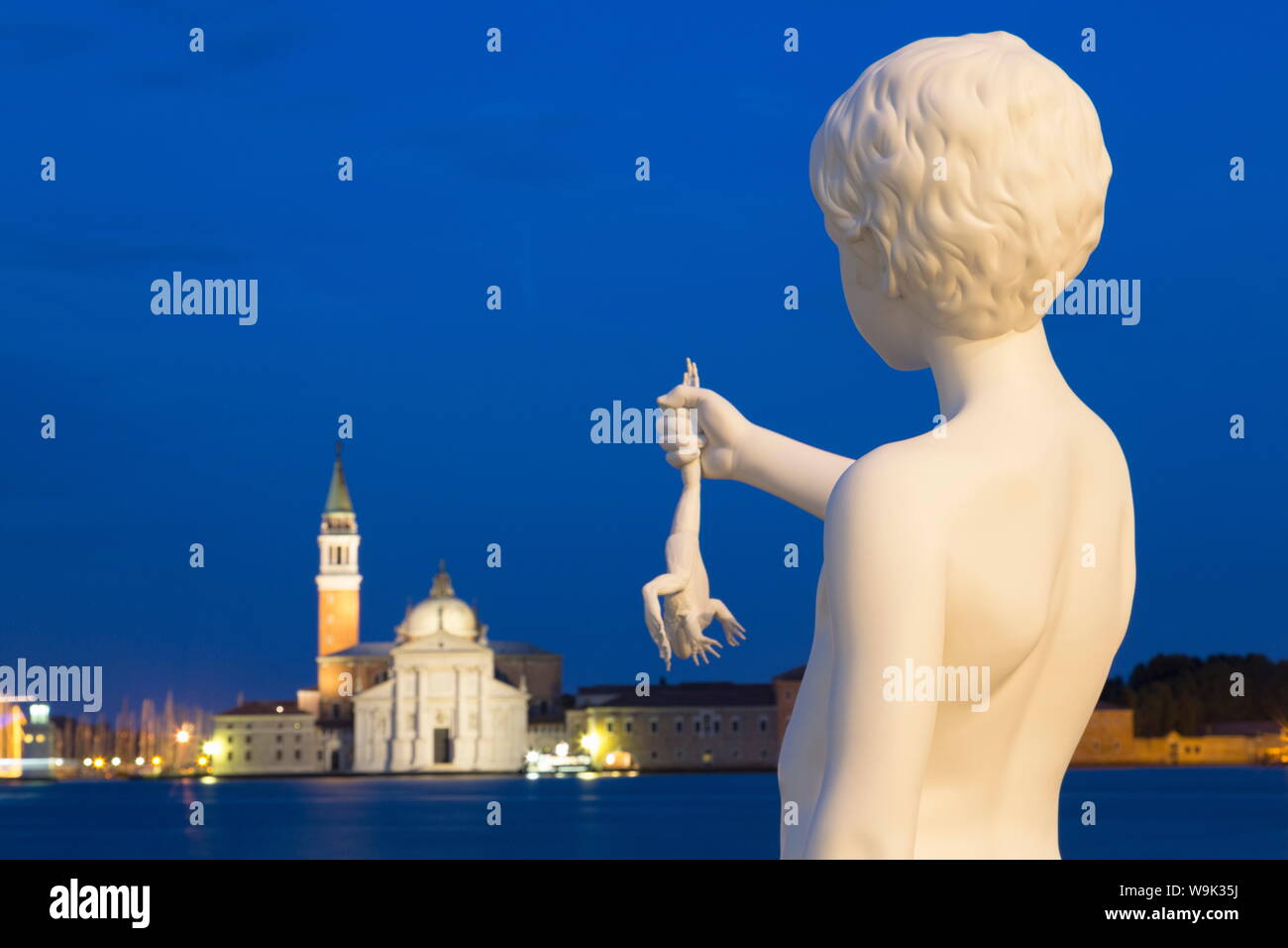 Night shot of Boy with Frog statue by Charles Ray, outside Dogana di Mare, with San Giorgio Maggiore in the distance, Venice, UNESCO, Veneto, Italy Stock Photo