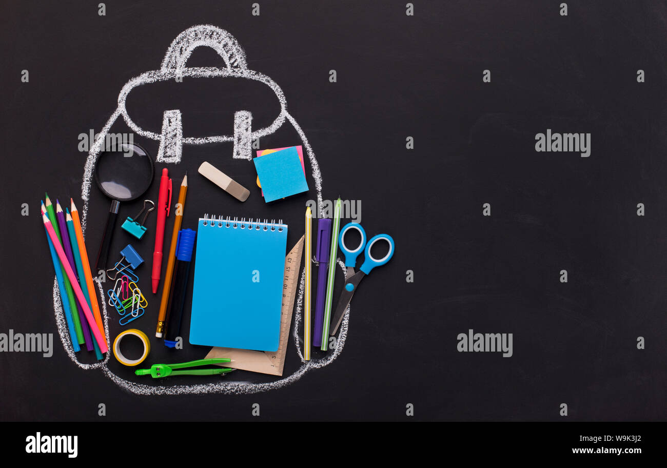 Chalk painted backpack with office supplies on black background Stock Photo