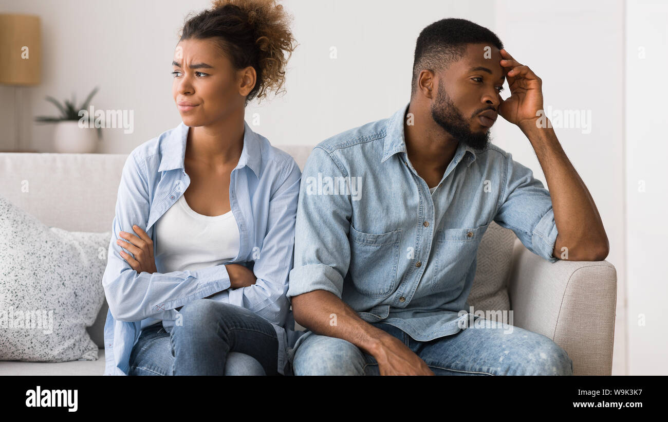 Sad african american couple sitting on couch looking away Stock Photo ...