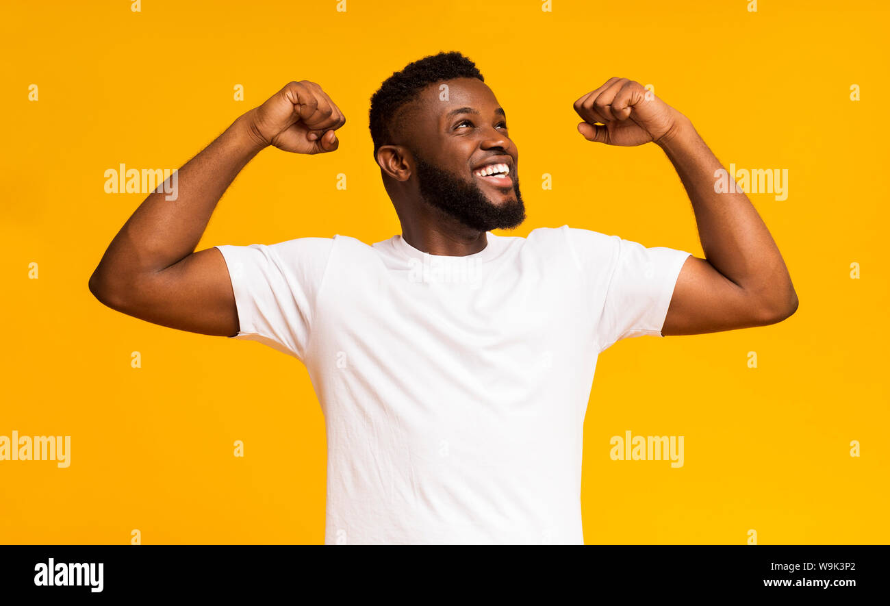 Cheerful guy showing arm muscles and smiling Stock Photo - Alamy