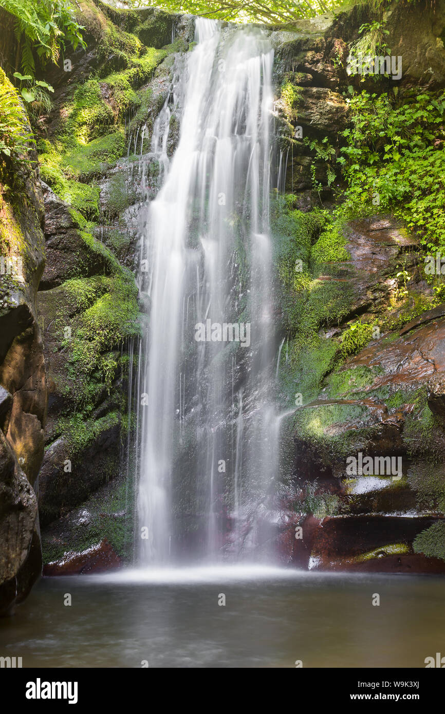 Wonderful long exposure mountain waterfall streaming down the red, wet ...