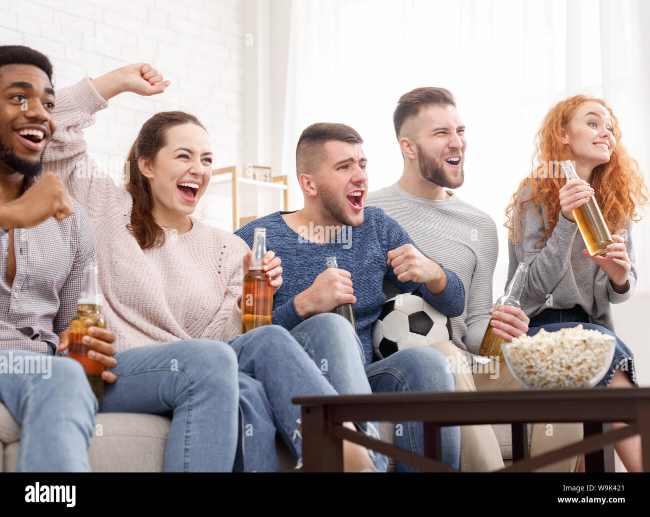 Happy friends cheering sport league, watching football Stock Photo