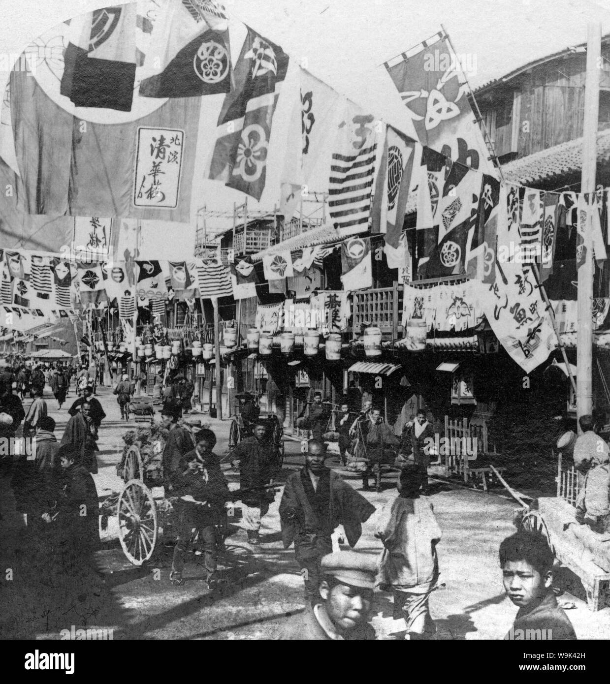 [ 1890s Japan - Flags in the Entertainment District in Osaka ] —   Dotonbori theater street in Osaka, ca 1896 (Meiji 29).  20th century vintage stereoview. Stock Photo