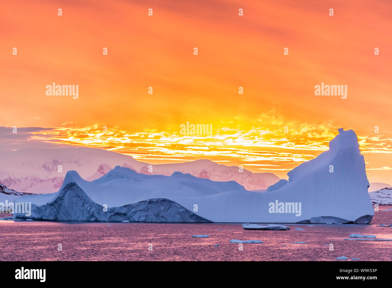 Sunset over ice floes and icebergs, near Pleneau Island, Antarctica, Southern Ocean, Polar Regions Stock Photo