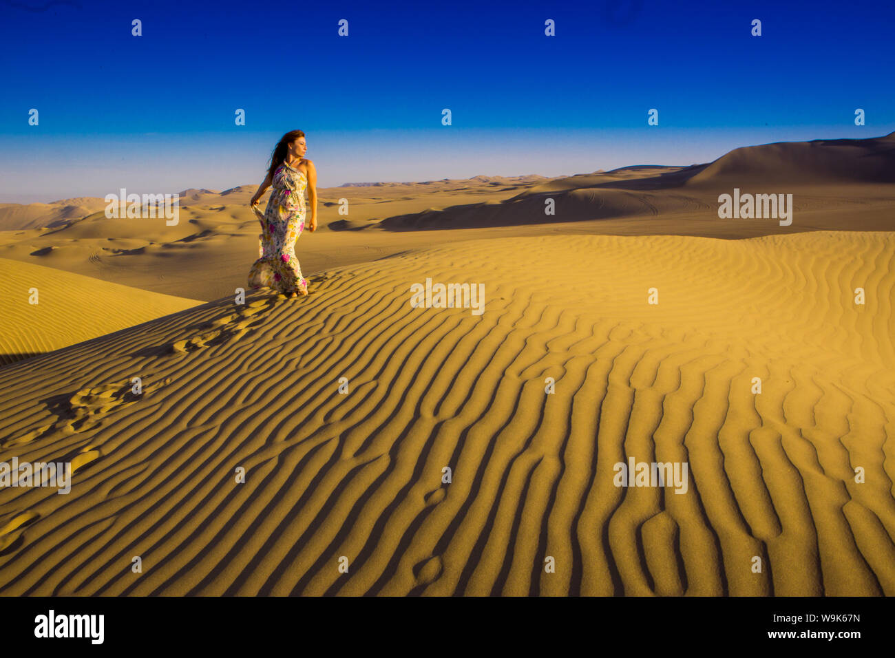 Girl standing on sand dunes at Huacachina Oasis, Peru, South America Stock Photo