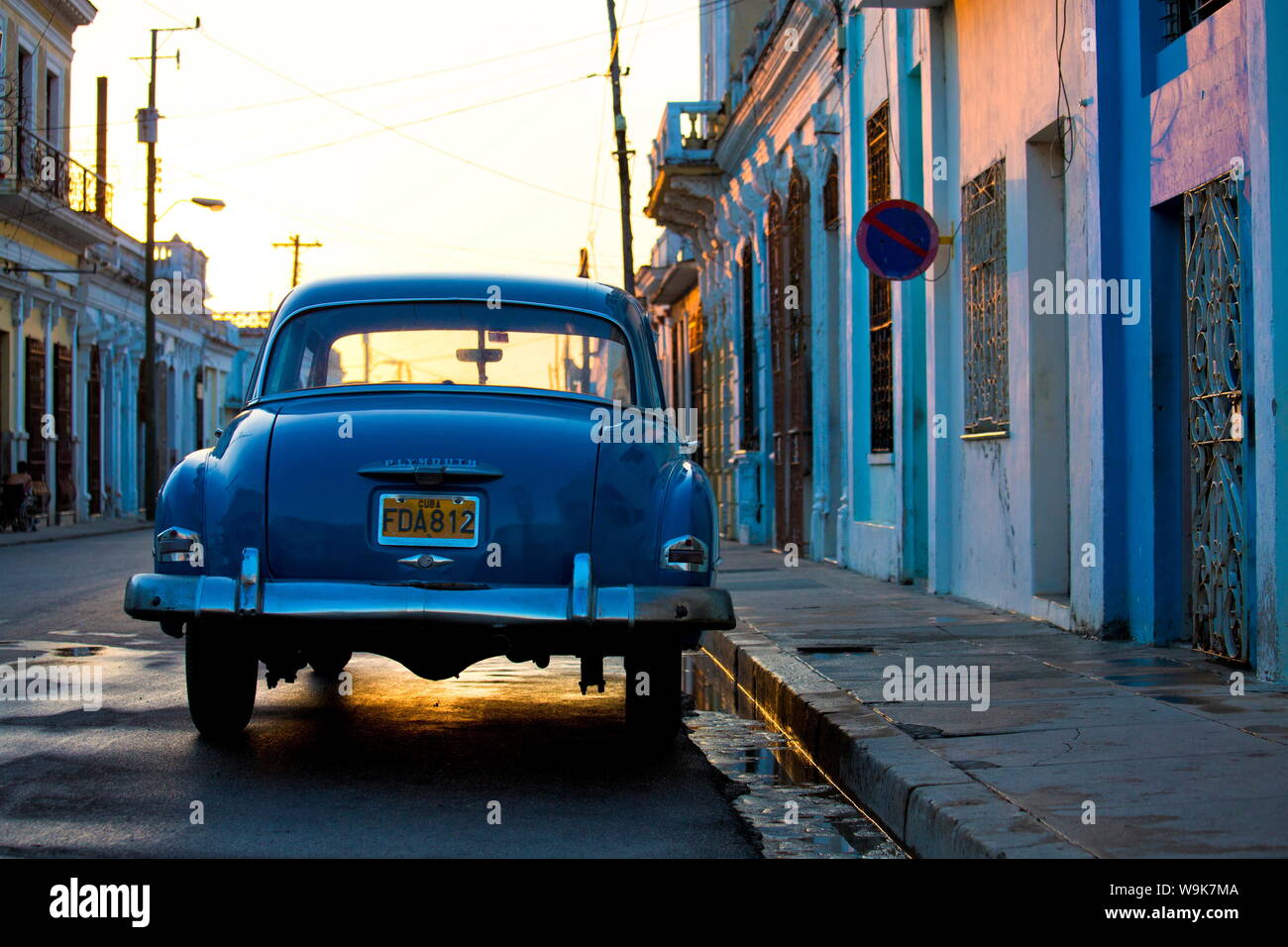 Vintage blue Plymouth American car backlit by the setting sun, Cienfuegos, Cuba, West Indies, Central America Stock Photo