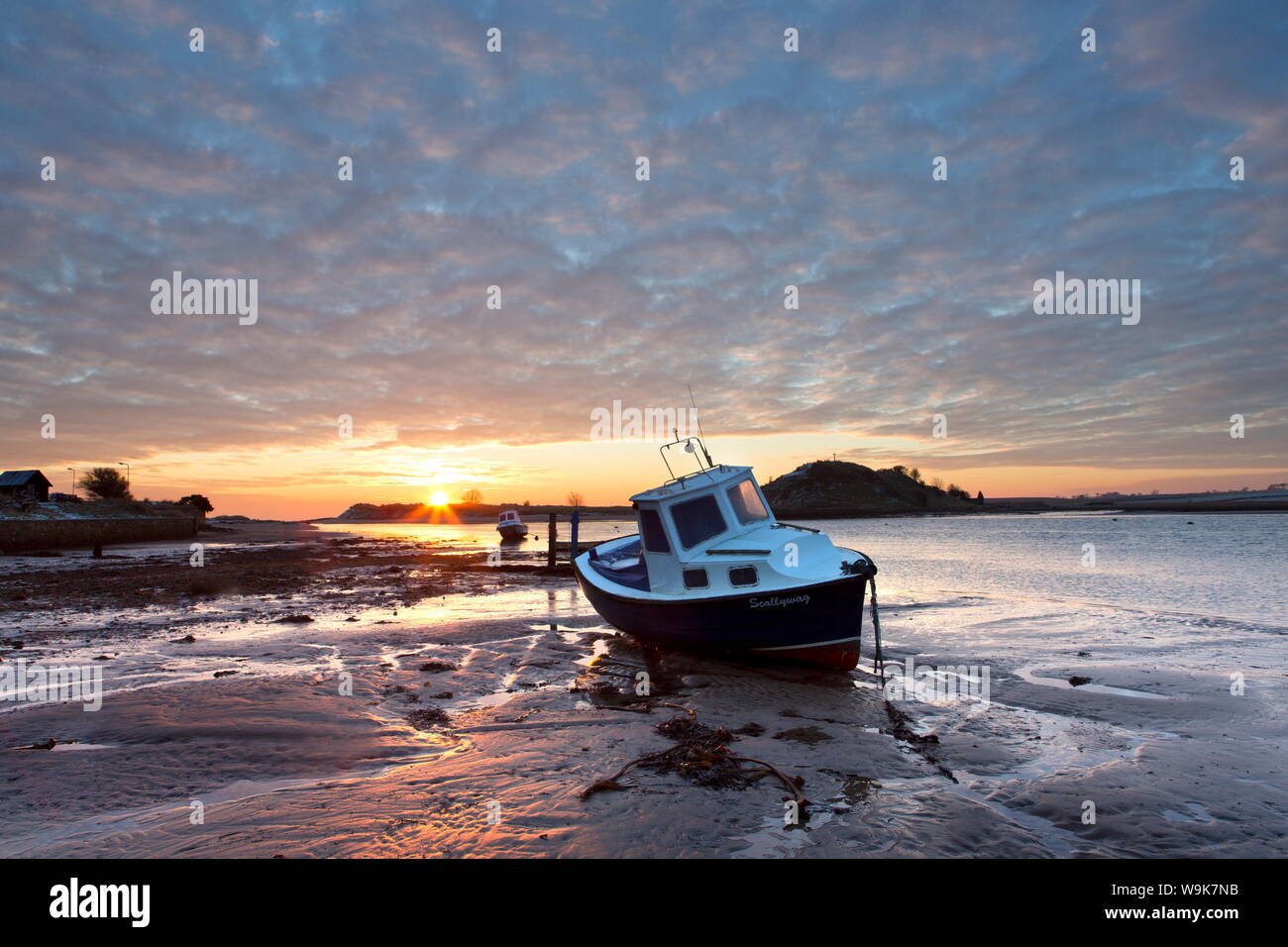 Winter sunrise on the Aln Estuary looking across the sand at low tide to Church Hill, Alnmouth, near Alnwick, Northumberland, England, United Kingdom Stock Photo
