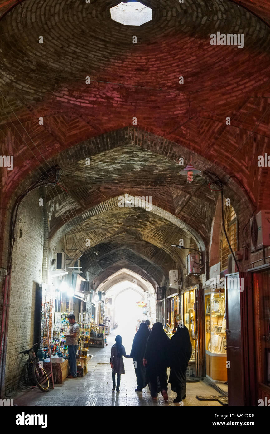 Girl and women in black chadors, Grand Bazaar, Isfahan, Iran, Middle East Stock Photo