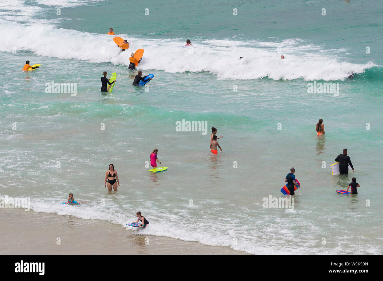 Holidaymakers cooling off in the sea in the hot summer weather at Great Western Beach in Newquay in Cornwall. Stock Photo