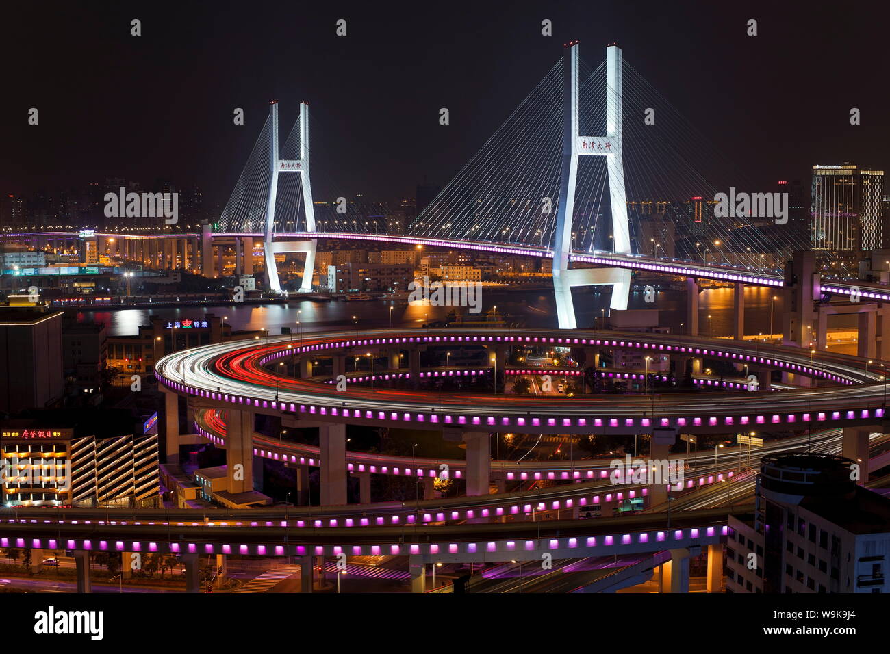 High angle wide shot traffic on Nanpu Bridge spiral and Bridge, illuminated at night, Shanghai, China, Asia Stock Photo