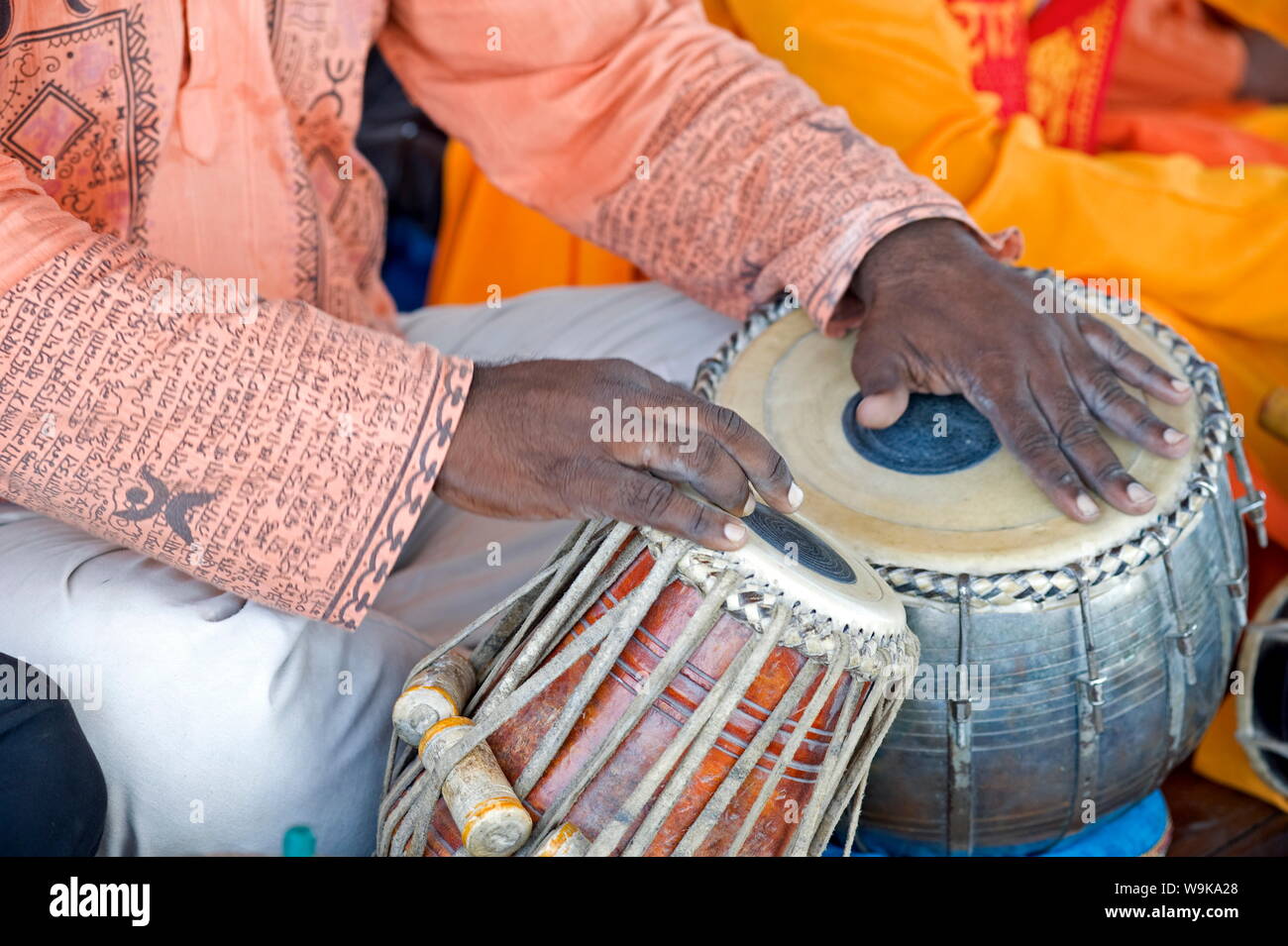 Hindu musician playing the tabla (drums) with typical black spot made from a mixture of gum