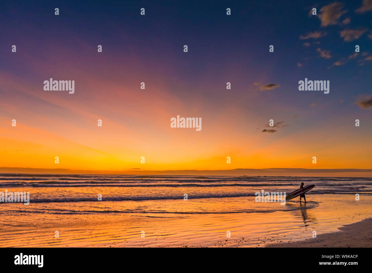 Sunset & surfer at Playa Guiones beach, Nosara, Nicoya Peninsula, Guanacaste Province, Costa Rica, Central America Stock Photo