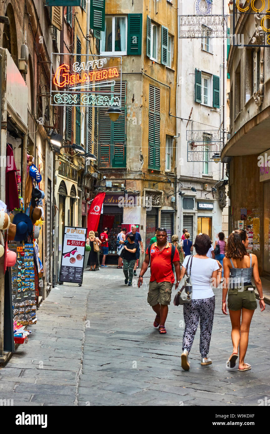 Genoa, Italy - July 06, 2019: Old street in Genoa with walking people Stock Photo