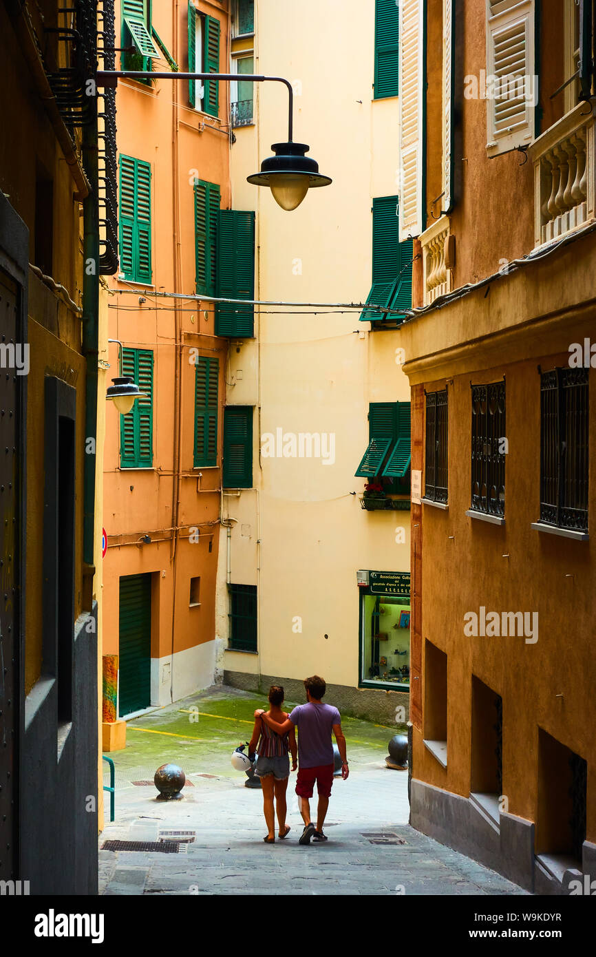 Genoa, Italy - July 06, 2019:  Old street in Genoa with walking couple Stock Photo