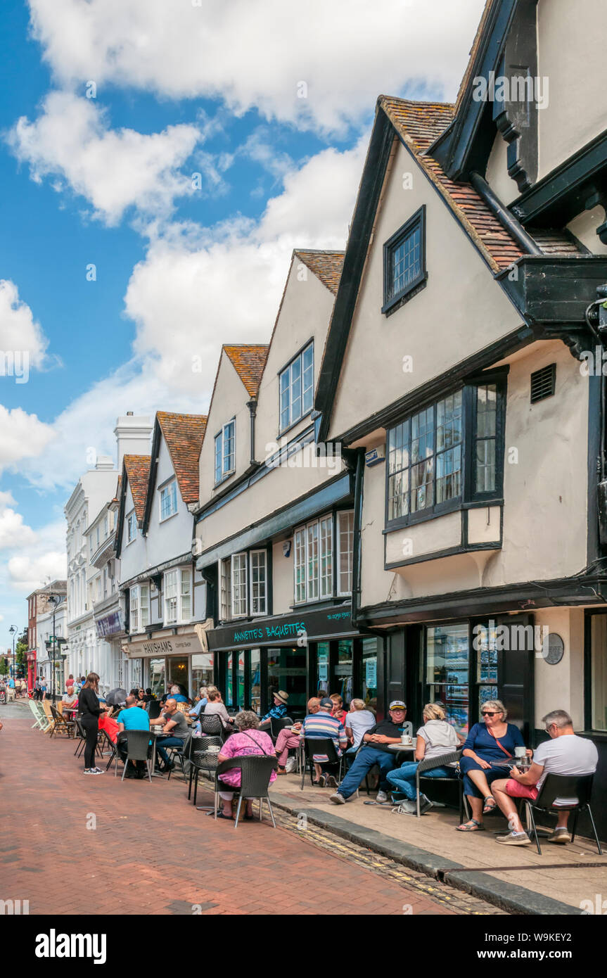 People sitting outside cafes in Court Street, Faversham, Kent. Stock Photo