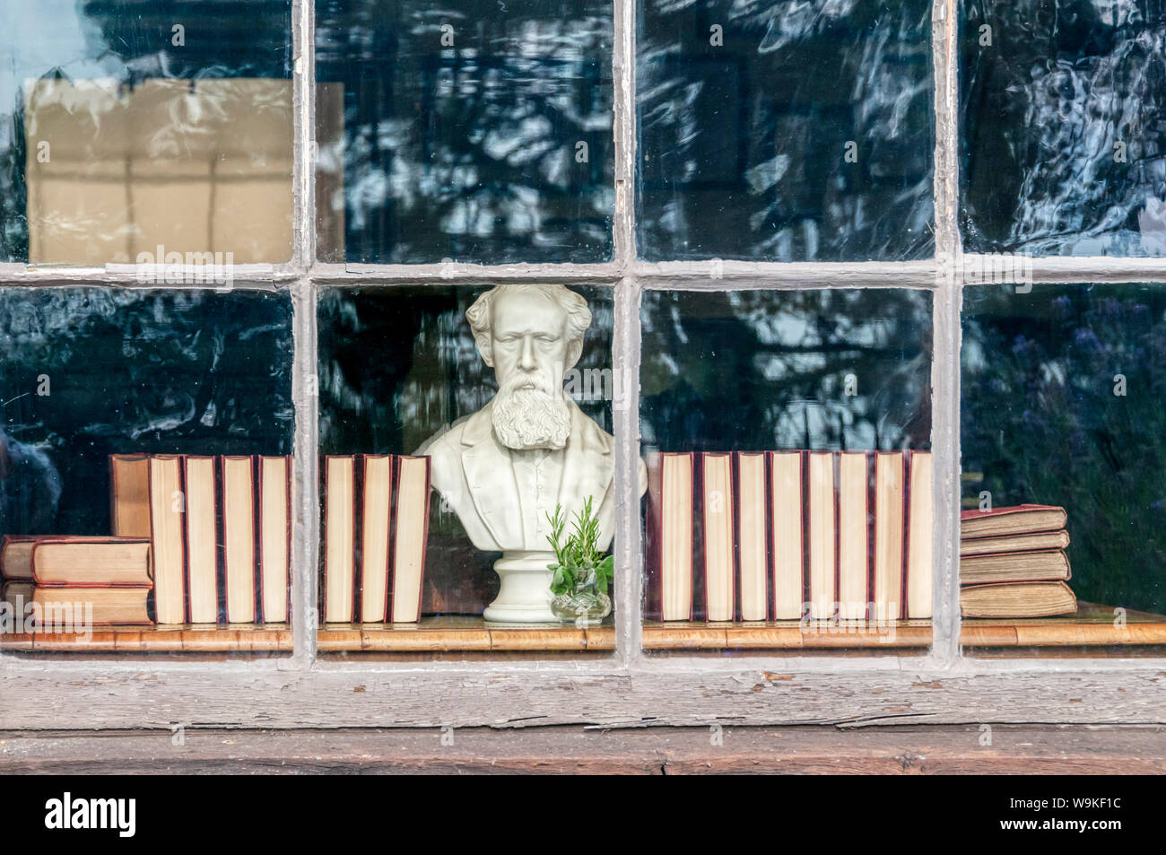 A bust of Charles Dickens looks out of a window of the Dickens House Museum in Broadstairs, Kent. Stock Photo